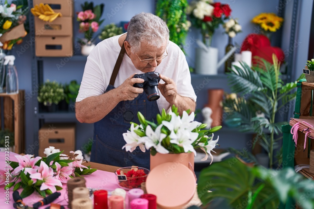 Middle age grey-haired man florist make photo to bouquet of flowers gift at florist
