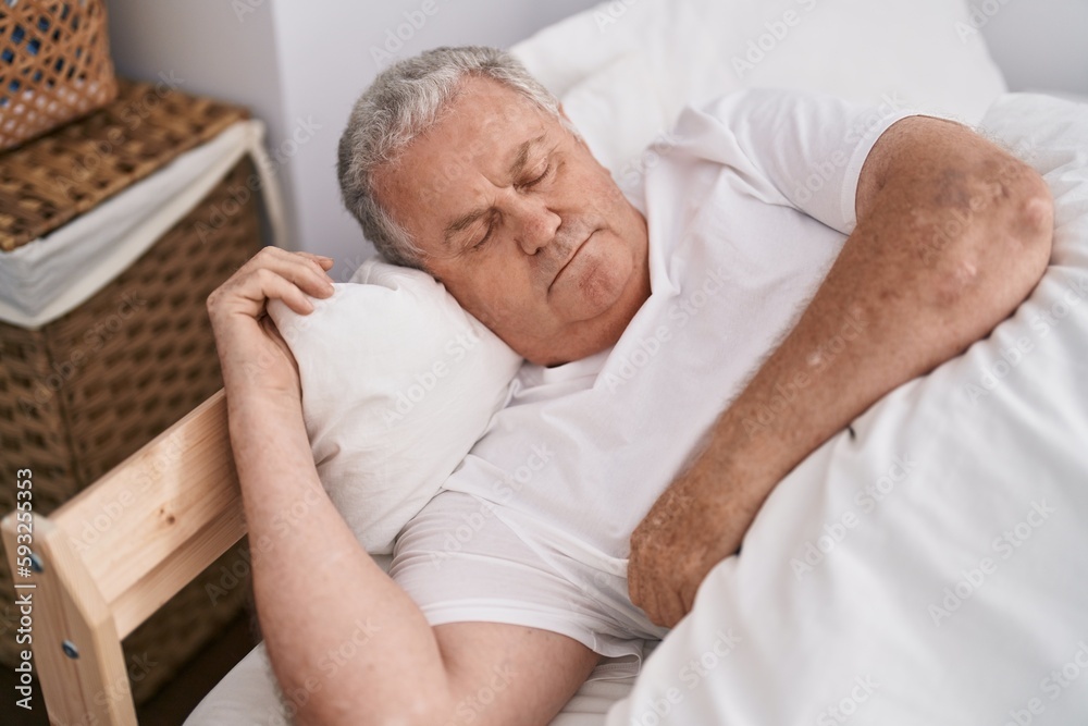 Middle age grey-haired man lying on bed sleeping at bedroom