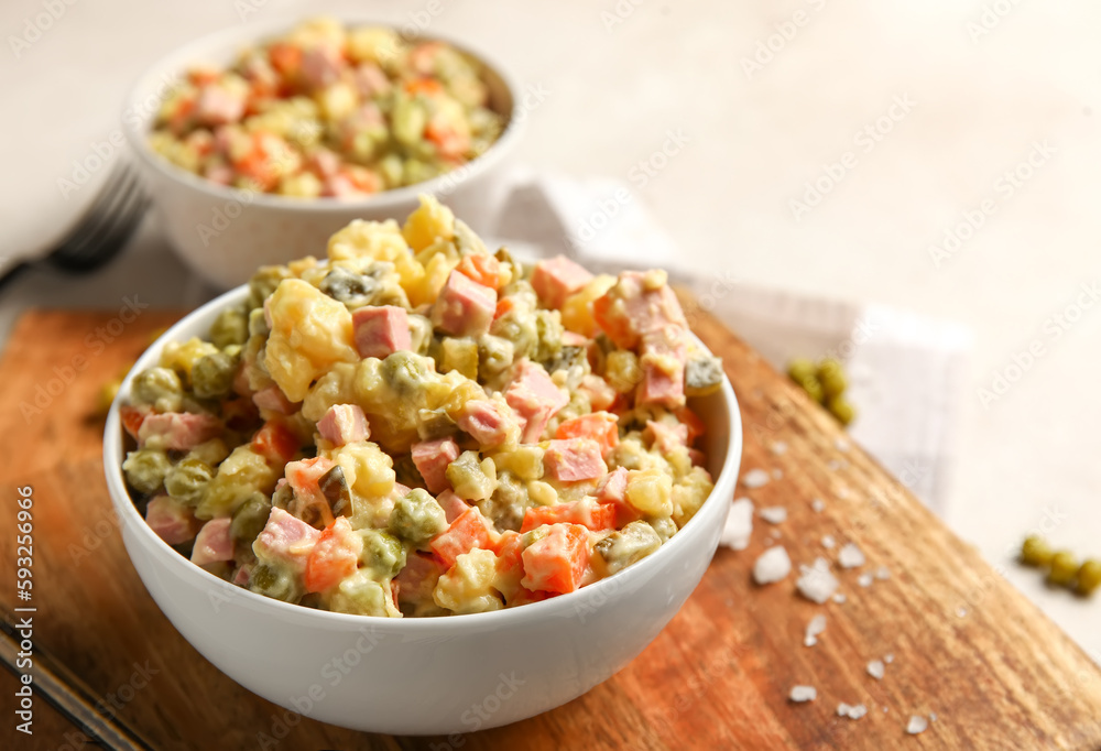 Bowl of tasty Olivier salad on light background, closeup Bowl of tasty Olivier salad on light background, closeup