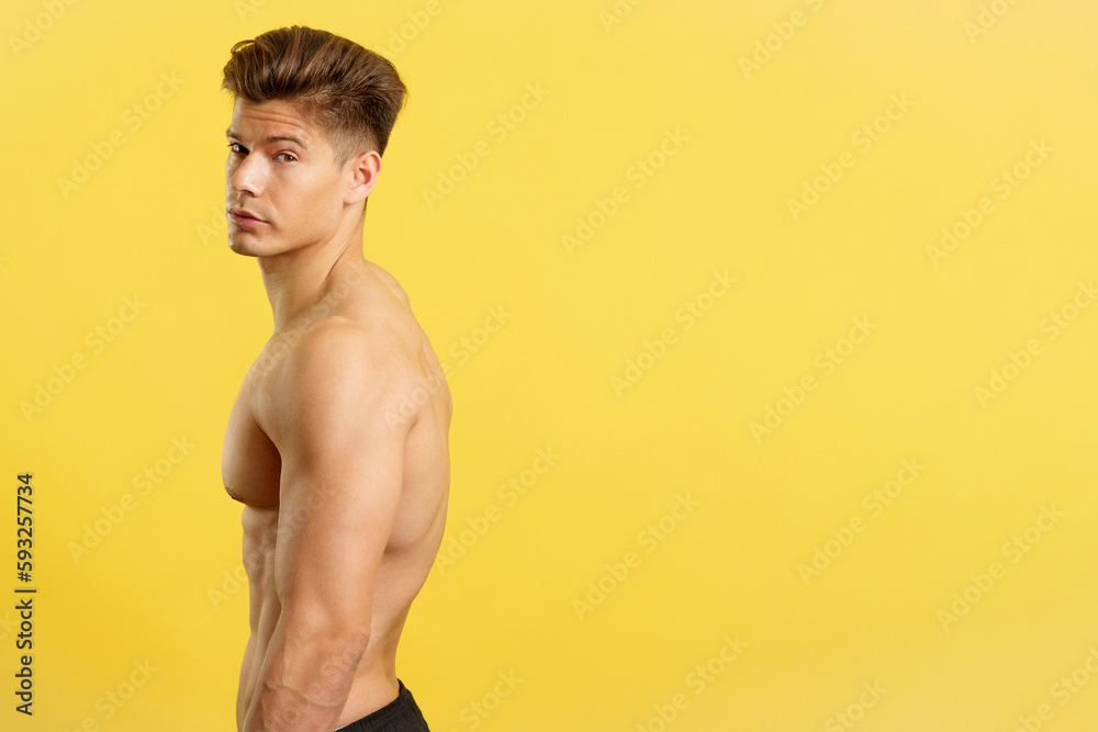 Fototapeta premium Handsome man with bare torso turning to looking at camera