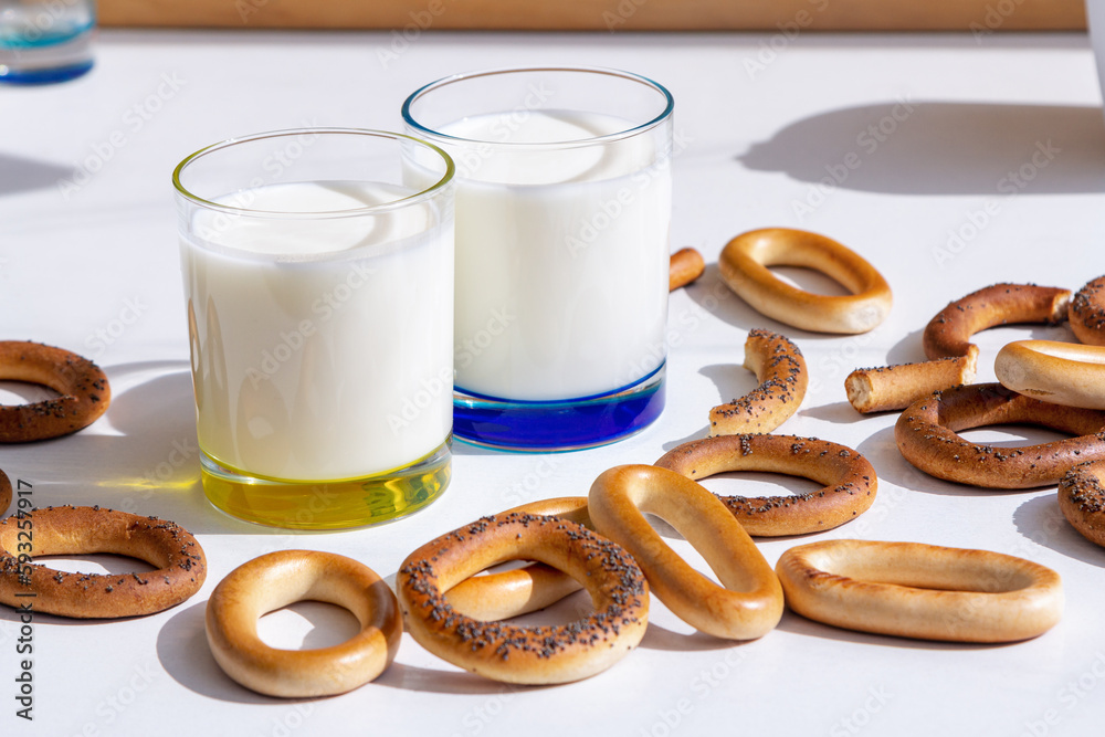 Fresh milk in glasses and bagels with poppy seeds on a table Fresh milk in glasses and bagels with poppy seeds on a table