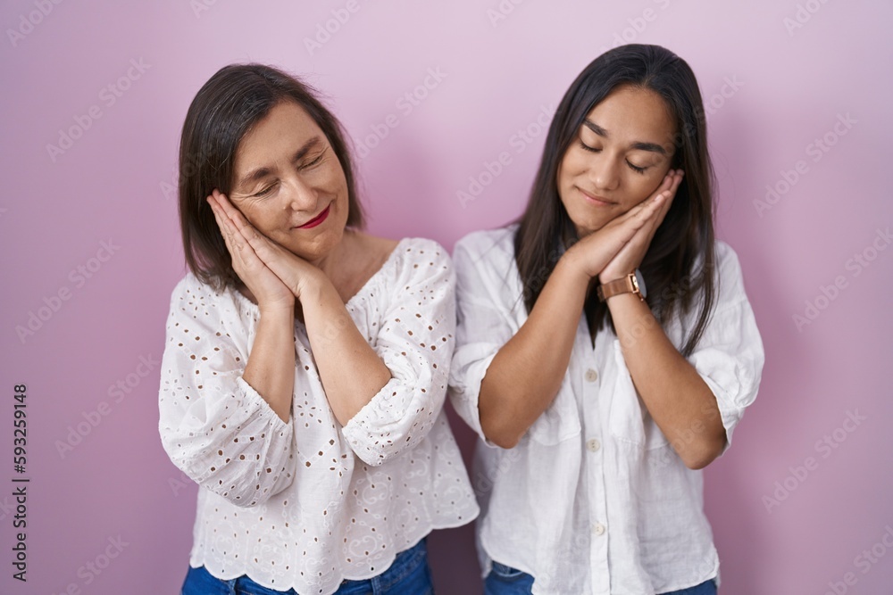 Hispanic mother and daughter together sleeping tired dreaming and posing with hands together while smiling with closed eyes. Hispanic mother and daughter together sleeping tired dreaming and posing with hands together while smiling with closed eyes.