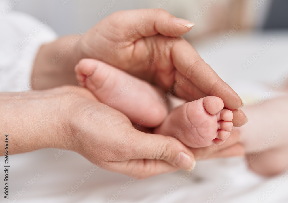 Adorable caucasian baby lying on bed having feet massage at bedroom Adorable caucasian baby lying on bed having feet massage at bedroom