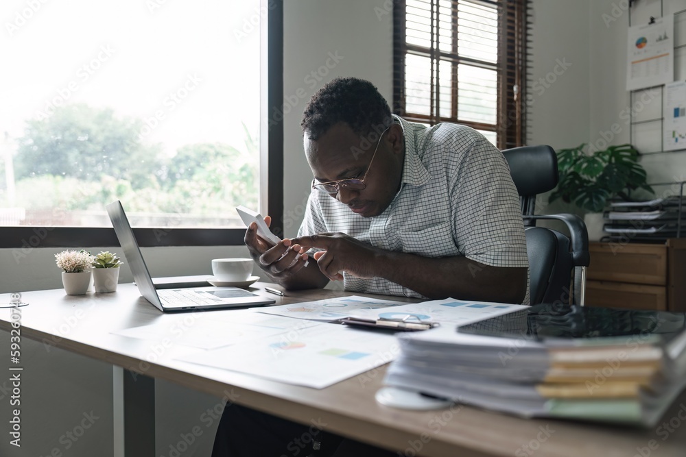 African American man calculating using machine managing household finances at home, focused biracial male make calculations on calculator account taxes or expenses African American man calculating using machine managing household finances at home, focused biracial male make calculations on calculator account taxes or expenses