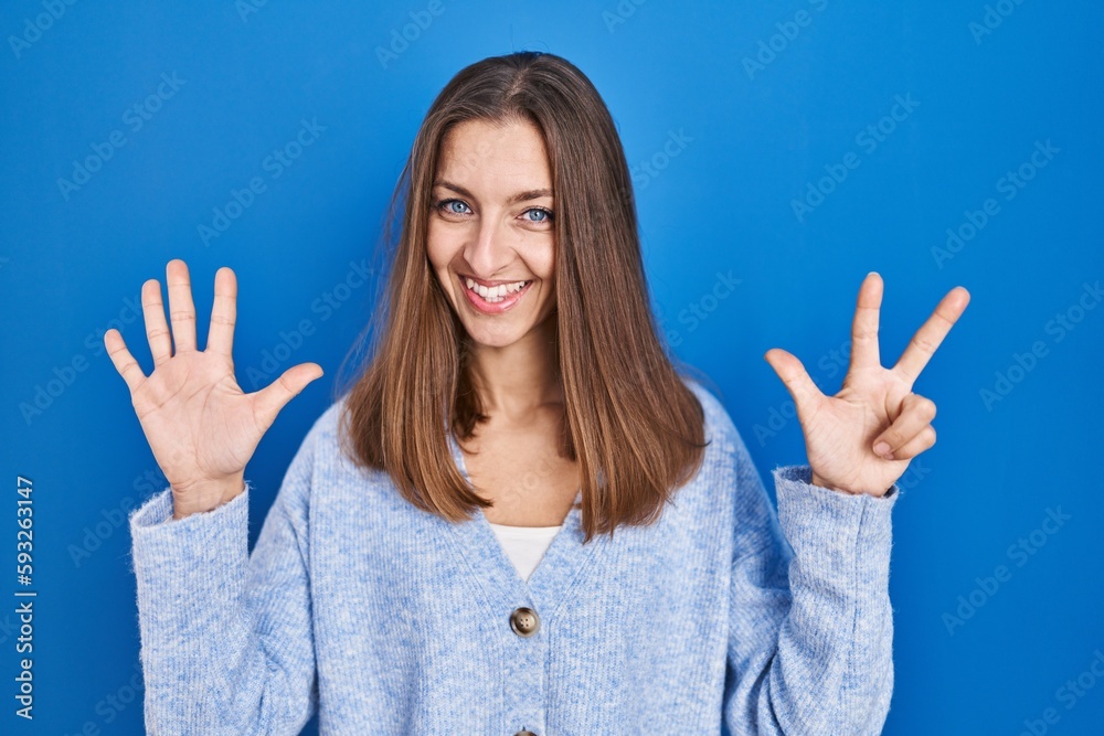 Young woman standing over blue background showing and pointing up with fingers number eight while smiling confident and happy. Young woman standing over blue background showing and pointing up with fingers number eight while smiling confident and happy.