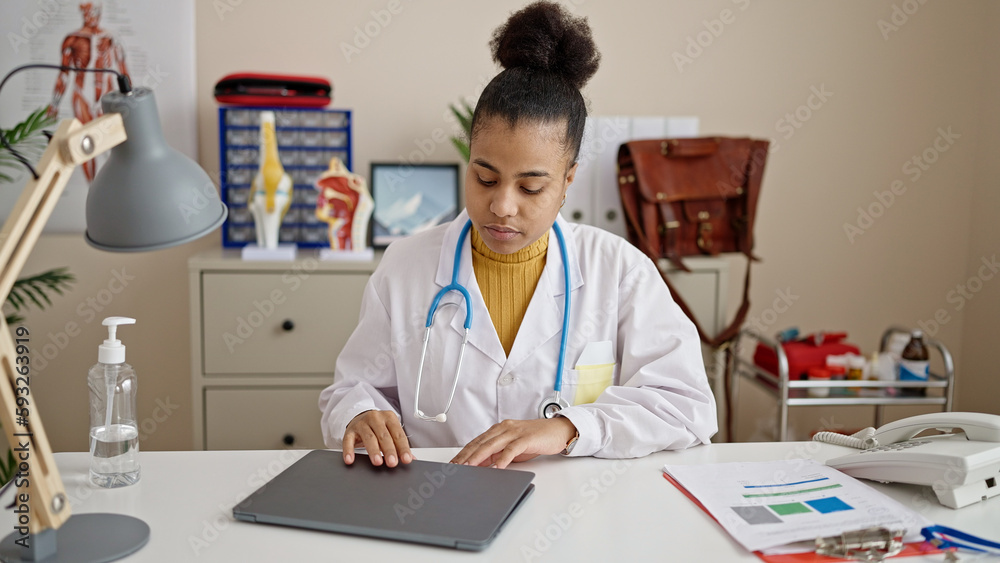 Young african american woman doctor using laptop working at clinic Young african american woman doctor using laptop working at clinic