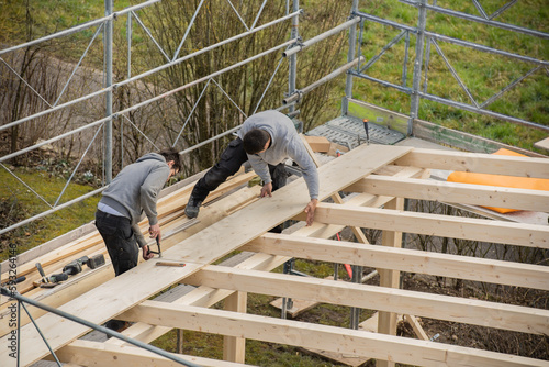 Two young carpenters building a carport.
