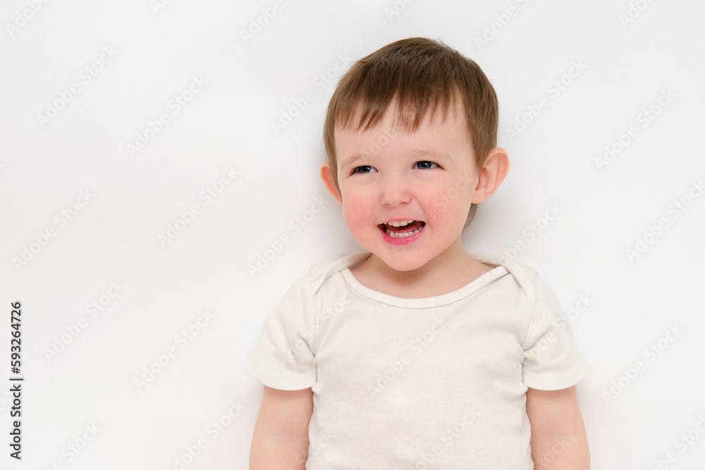 A happy baby on a studio white background. Portrait of a smiling child. Kid aged about two years (one year nine months) A happy baby on a studio white background. Portrait of a smiling child. Kid aged about two years (one year nine months)