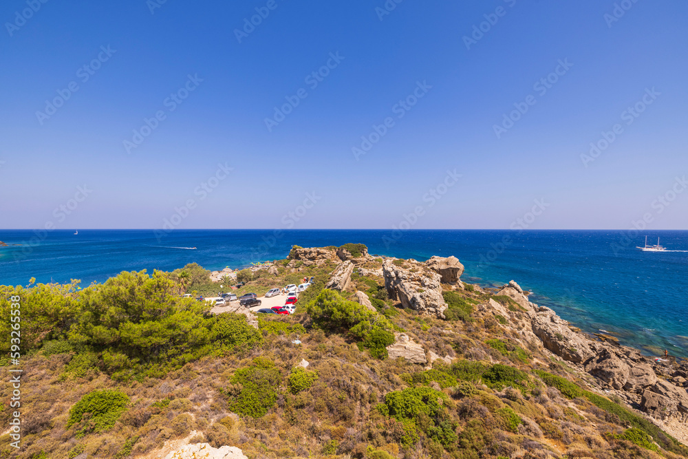 Beautiful view of mountainous Mediterranean coast with car parking in distance. Greece.