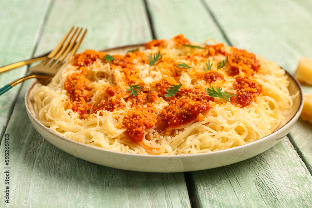 Plate of tasty Italian pasta with Parmesan cheese on light wooden background Plate of tasty Italian pasta with Parmesan cheese on light wooden background