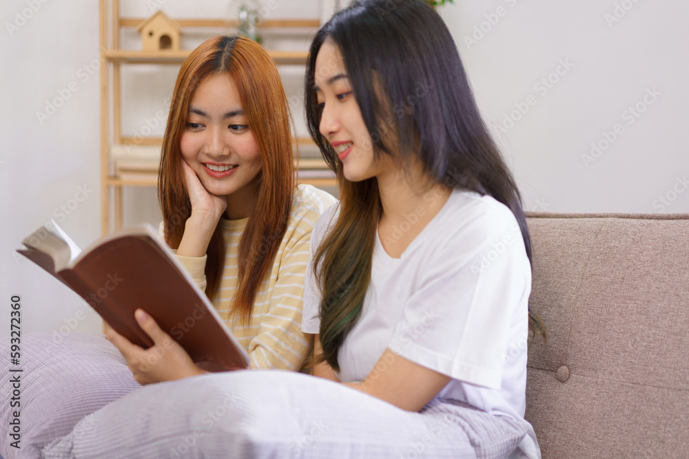 Activity at home concept, LGBT lesbian couple reads and learning holy bible together in living room Activity at home concept, LGBT lesbian couple reads and learning holy bible together in living room