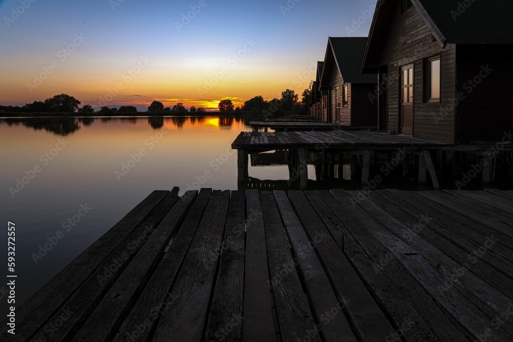 Line off wooden houses on a lake during the sunset