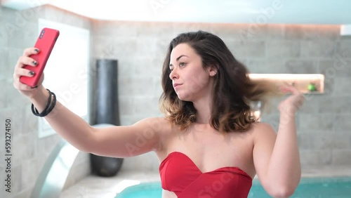 Pretty woman taking a selfie with the phone in the spa