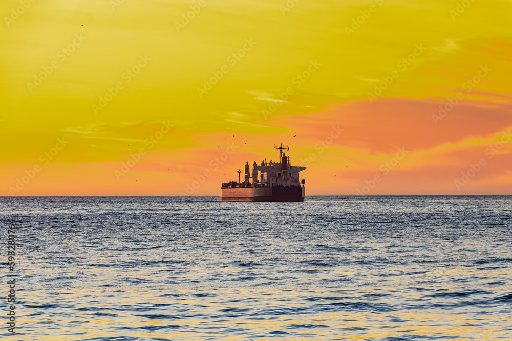 ship moving away towards the horizon during sunset ship moving away towards the horizon during sunset