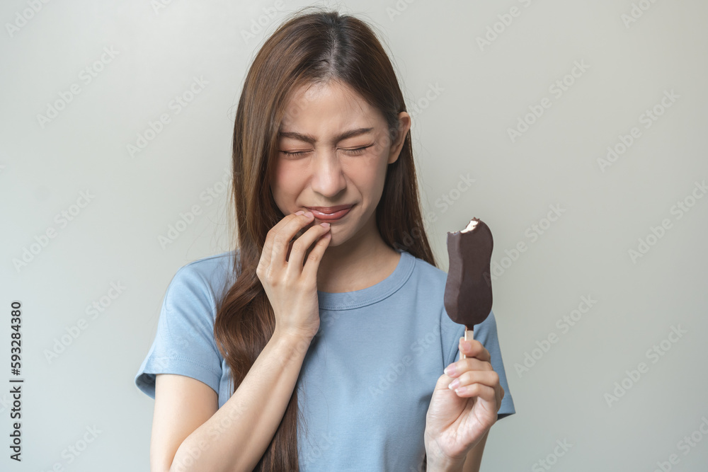 Face expression suffering from sensitive teeth and cold, asian young