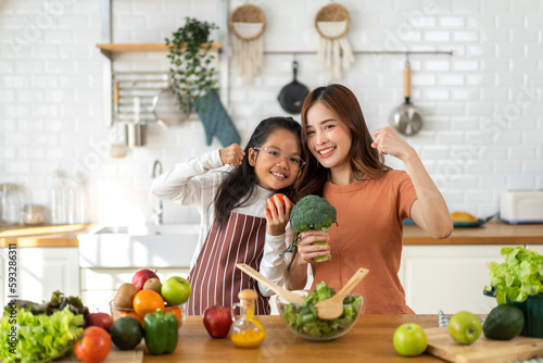 Portrait of enjoy happy love asian family mother with little asian girl daughter child having fun help cooking food healthy  strong  eat together with fresh vegetable salad ingredient in kitchen