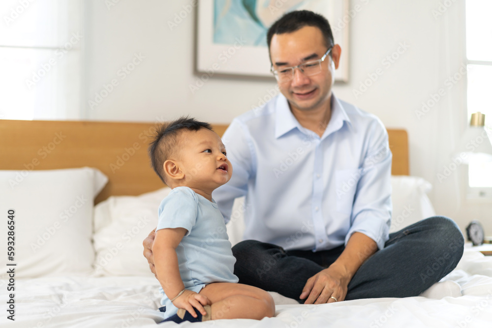 Portrait of enjoy happy love family asian father playing with adorable little asian baby.newborn, infant.dad touching with cute son moments good time in a white bedroom.father day, Love of family Portrait of enjoy happy love family asian father playing with adorable little asian baby.newborn, infant.dad touching with cute son moments good time in a white bedroom.father day, Love of family