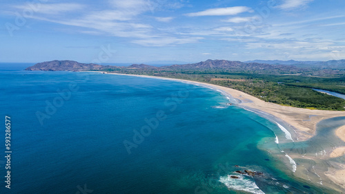 Aerial Drone View of a tropical island with lush jungle in Costa Rica, Isla del Caño, Beautiful view of boats