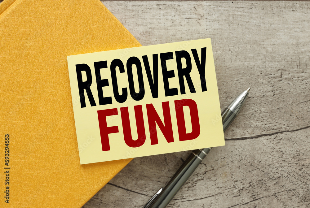 Obraz premium recovery fund yellow sticker on a yellow notebook. on a wooden table