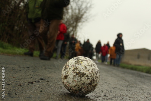 Boßelkugel weß mit Menschen im Hintergrund, weiss