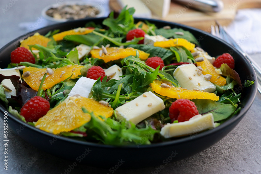 close up of a vegetarian green salad with oranges and brie cheese 
