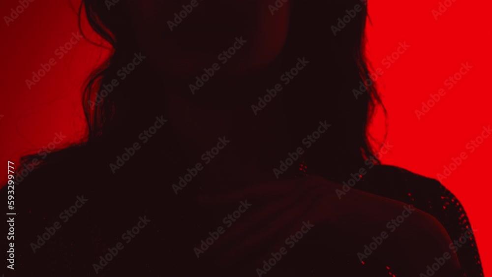 Young beautiful confident brunette female in trendy evening shiny green reflecting dress. Sexy carefree woman isolated on red neon light in studio. Fashionable model. high fashion Young beautiful confident brunette female in trendy evening shiny green reflecting dress. Sexy carefree woman isolated on red neon light in studio. Fashionable model. high fashion