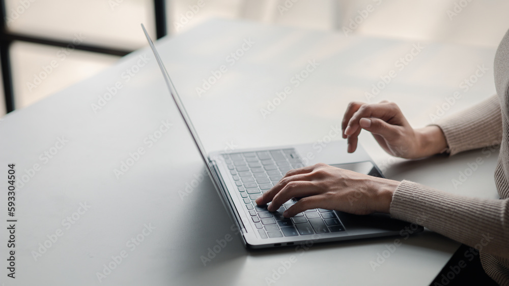 Person typing on laptop keyboard, businessman working on laptop, he is typing messages to colleagues and making financial information sheet to sum up the meeting.