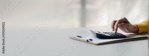 Businessman using a calculator to calculate numbers on a company's financial documents, she is analyzing historical financial data to plan how to grow the company. Financial concept.