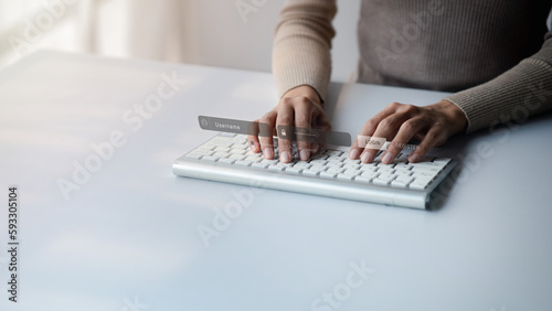An individual is typing on a laptop keyboard showing a hologram interface to a member login  a businessman is going to access the company s membership system  check the information of the parties.