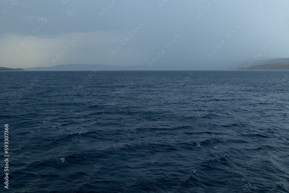 Scenic shot of the wavy sea surface under the stormy sky