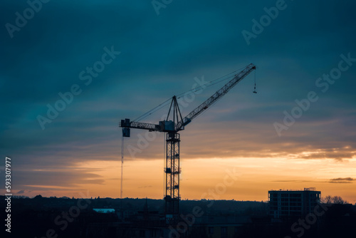 Construction crane at twilight, with cityscape background. High quality generative ai