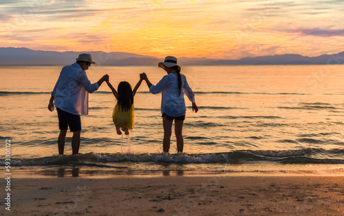 Happy Asian family travel tourist and playing water together having fun and enjoying on beach in summer vacation holiday.