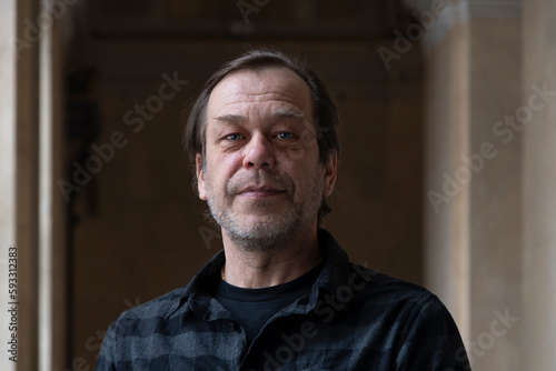 portrait of a man 40-50 years old in a shirt on a neutral blurred background indoors, marble walls. Perhaps he is just a buyer, an actor or a truck driver, a loader or a military pensioner,