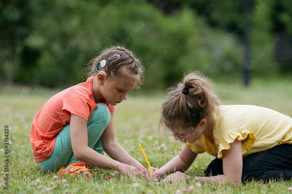 Two 8 years old girls drawing together in park. Two 8 years old girls drawing together in park.