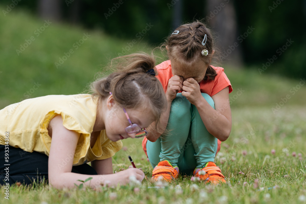 Girl crying in park while playing with friend. Girl crying in park while playing with friend.