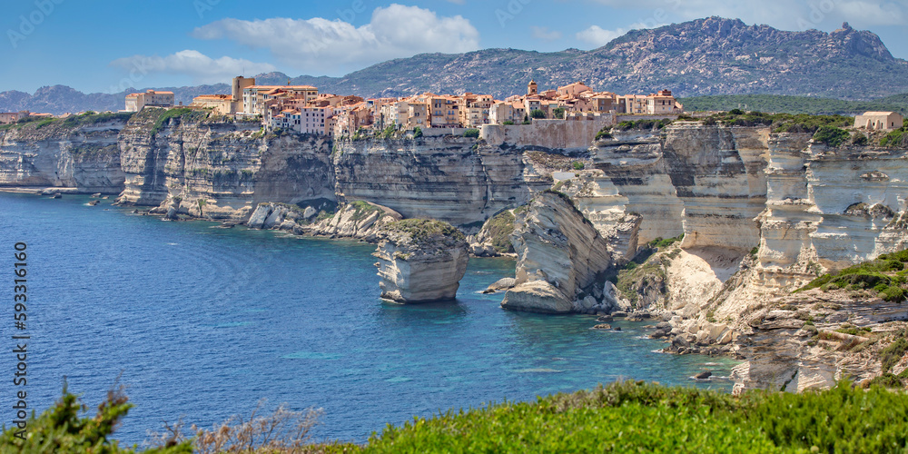 Bonifacio at the edge of the chalk cliffs. Bonifacio is situated on the cliffs of a limestone peninsula sculpted and eroded by the sea, with buildings overhanging the edge, Corsica island, France