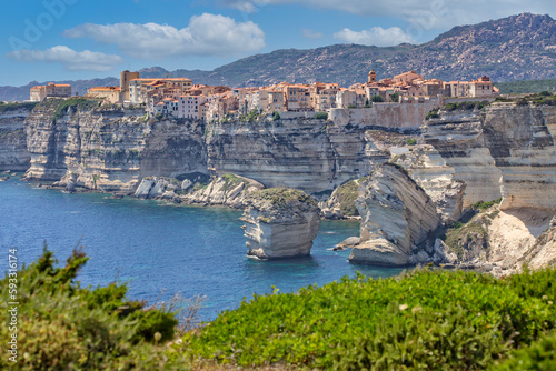 Bonifacio at the edge of the chalk cliffs. Bonifacio is situated on the cliffs of a limestone peninsula sculpted and eroded by the sea, with buildings overhanging the edge, Corsica island, France