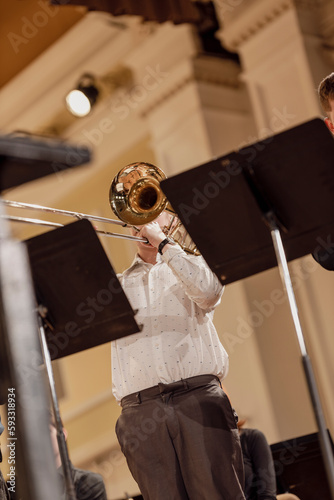 A musician playing the trombone during a live trombone ensemble performance