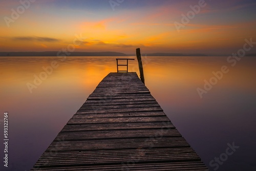 Beautiful view of a sunset over the wooden dock in a Plauer See lake