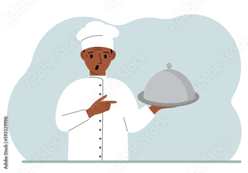 A male chef with a plate covered with a cloche or a tray with a lid.