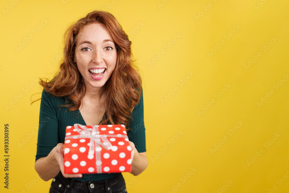 Redheaded woman smiling at camera with a gift Redheaded woman smiling at camera with a gift
