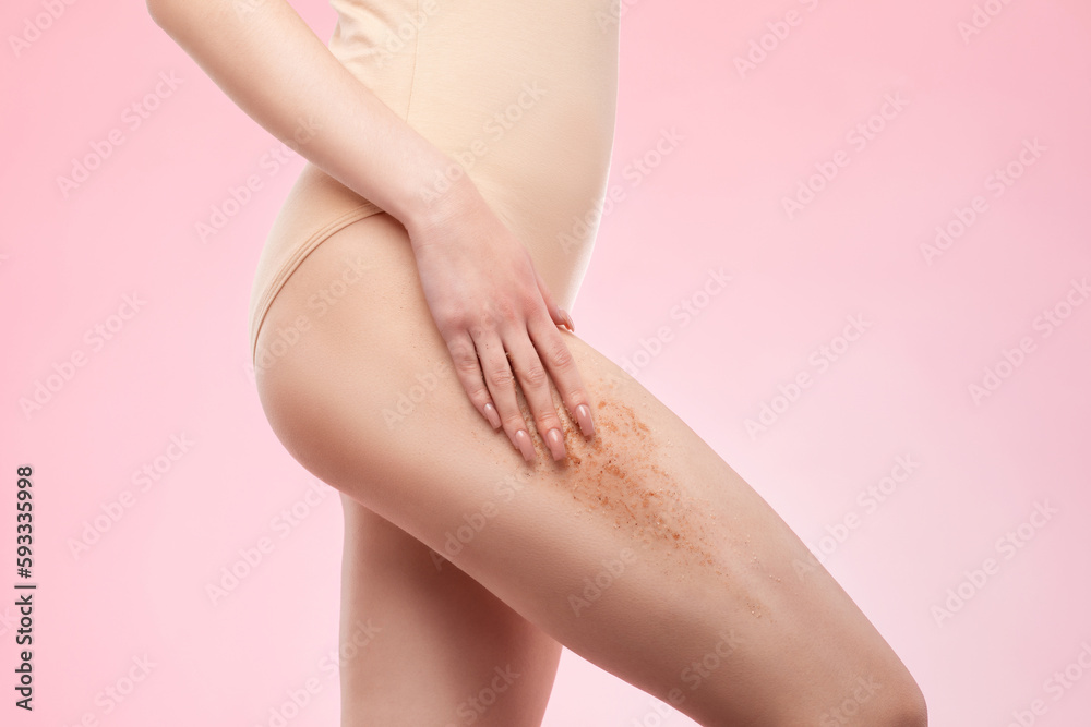 The girl makes a cosmetic peeling procedure on the thighs of a woman. Spa procedures in a beauty salon.