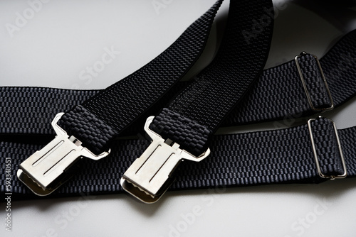 Suspenders for pants on a white background. Gray suspenders with crocs.