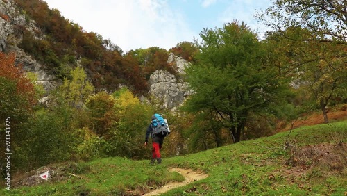 Male hiker walking on a trail in Cernei mountains, Romania photo