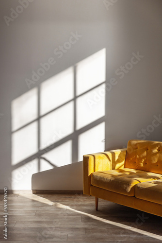 Interior with yellow sofa against background of shadows from window