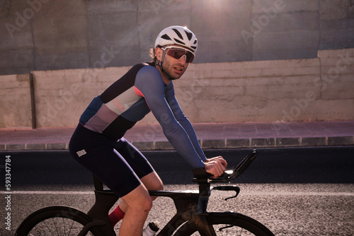 Obraz na plátně Fit male athlete on time trial aero bike in a relaxed position, riding his bike during recovery after doing a hard session of anaerobic training