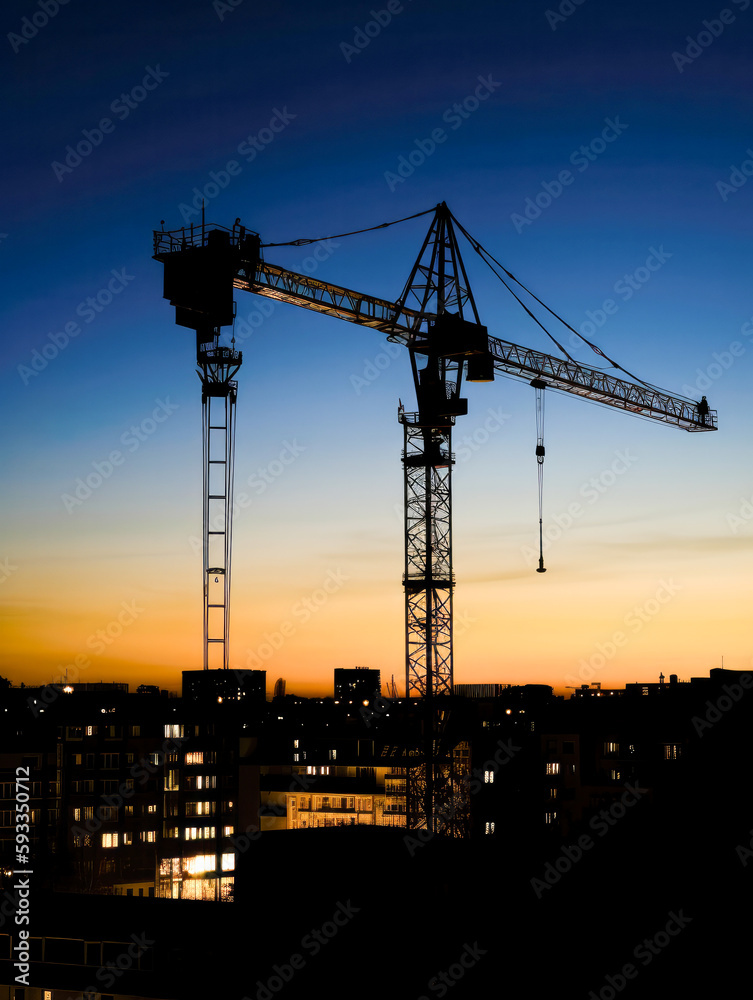 Construction crane silhouette at sunset with cityscape at background, vertical photo. High quality generative ai