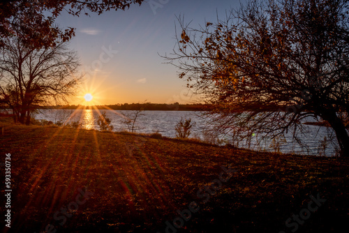 Sunset and Sun star over a lake