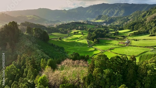 Aerial shot of green meadows, mountains and Furnas city on Sao Miguel Island, Azores, Portugal . Azores nature on sunny day photo