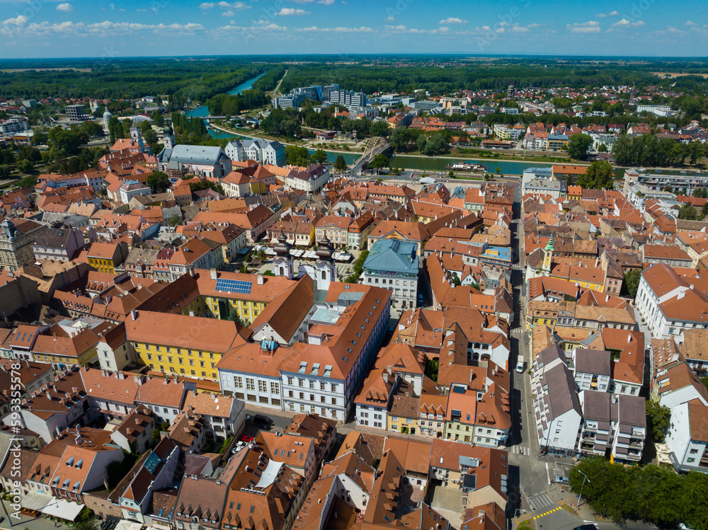 Aerial shot of Gyor city center, Hungary. Central square, houses with tiled roofs and the river in Gyor